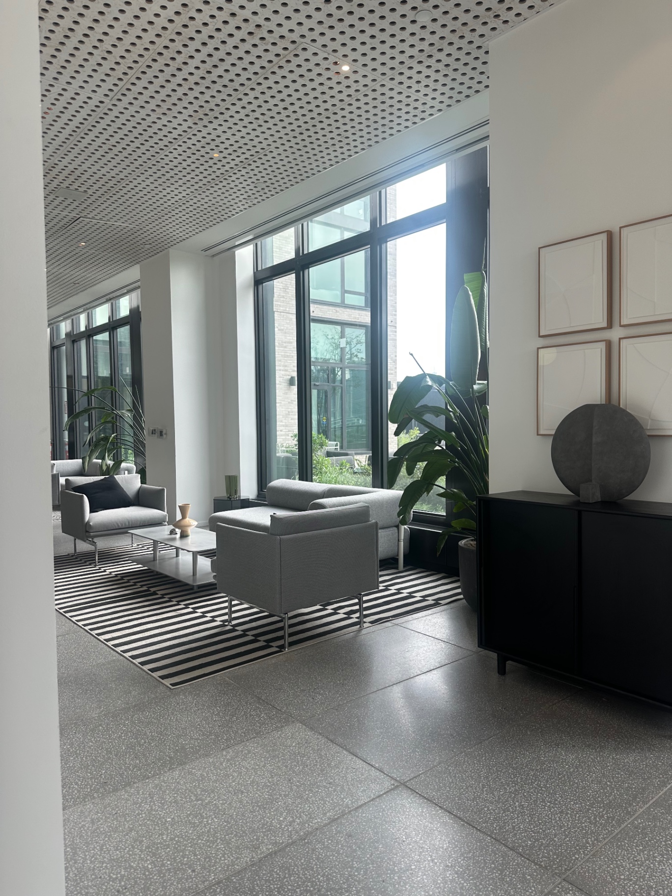 Indoor coworking lounge with floor-to-ceiling windows and plants