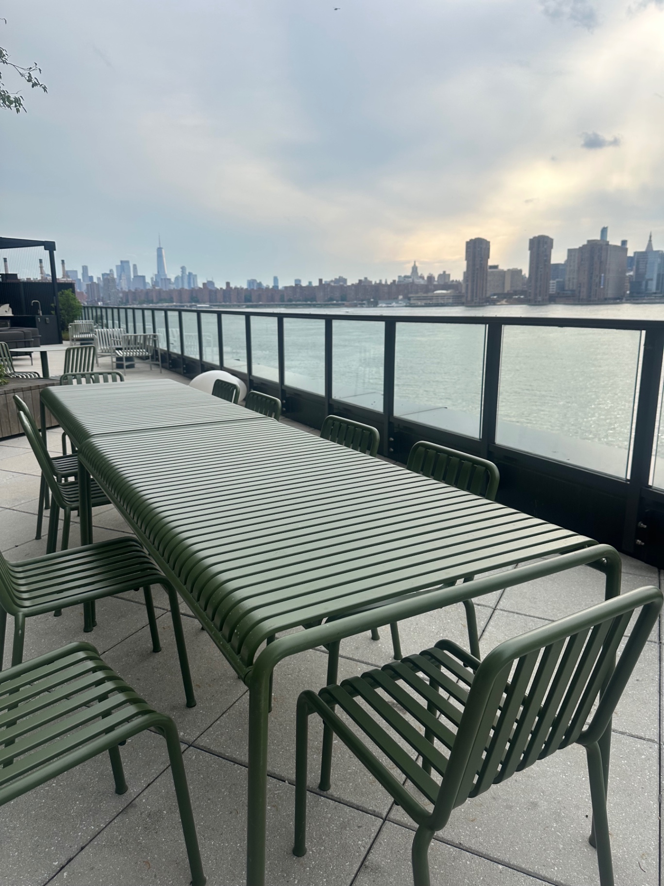 Long outdoor dining table on the terrace overlooking the river toward Lower Manhattan